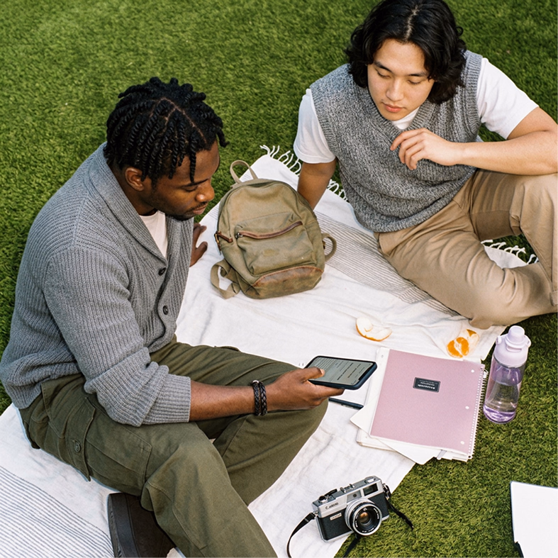 Two people sitting together on the grass.